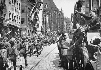 Baldur von Schirach (saluting), leader of the Hitler Youth, and Julius Streicher (in light-colored jacket), editor of the antisemitic newspaper, "Der Stuermer," review a parade of Hitler Youth in Nuremberg. [Photograph #08063]
